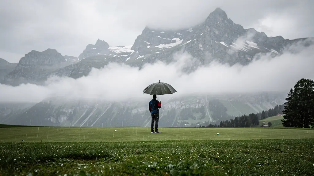 Golfeur se préparant à jouer sous la pluie sur un parcours de montagne en Suisse