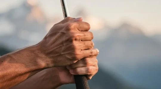 Gros plan sur les mains d'un golfeur saisissant un club avec la pression idéale, atmosphère lumineuse et professionnelle